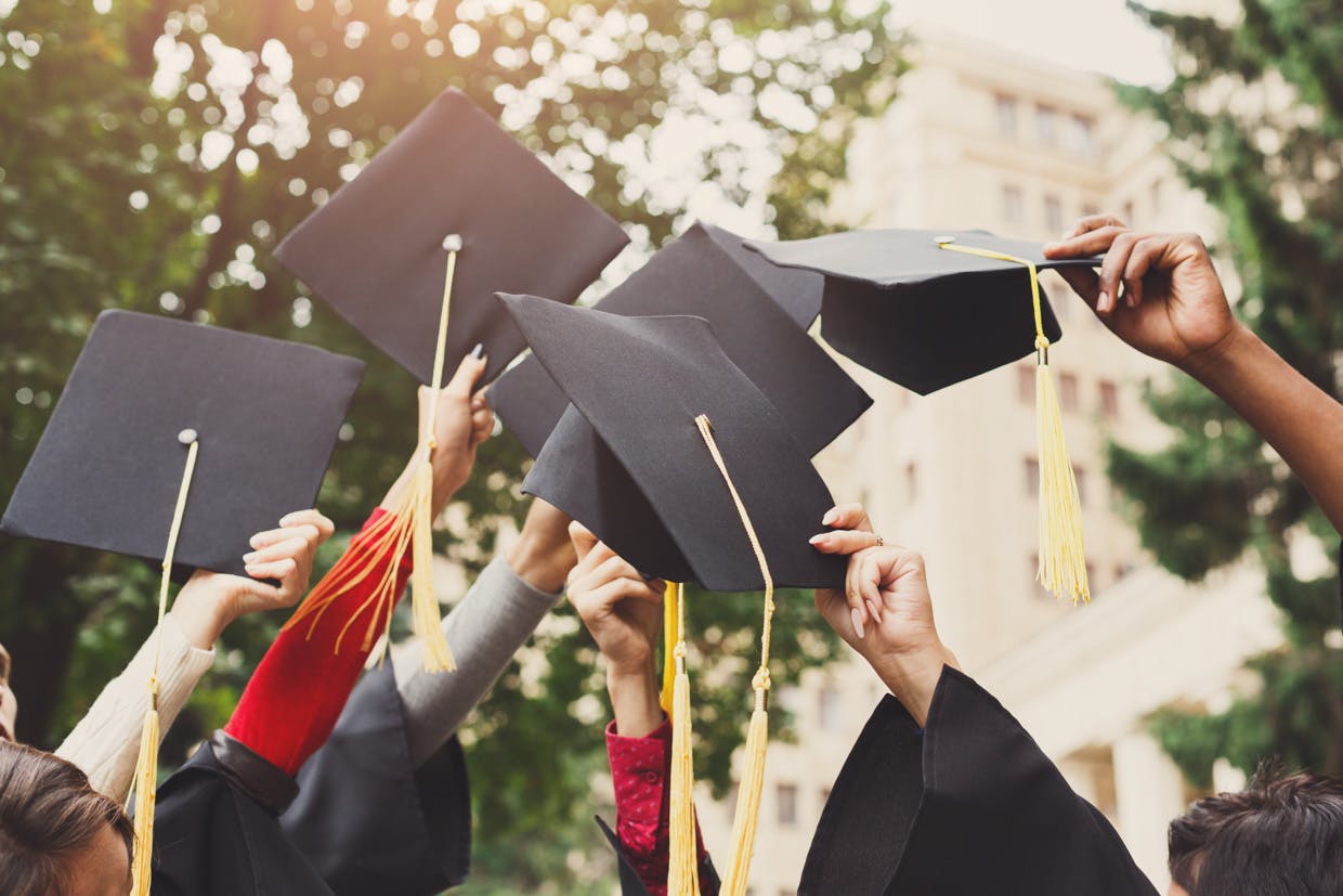 A stock photo of people throwing their graduation hats in the air
